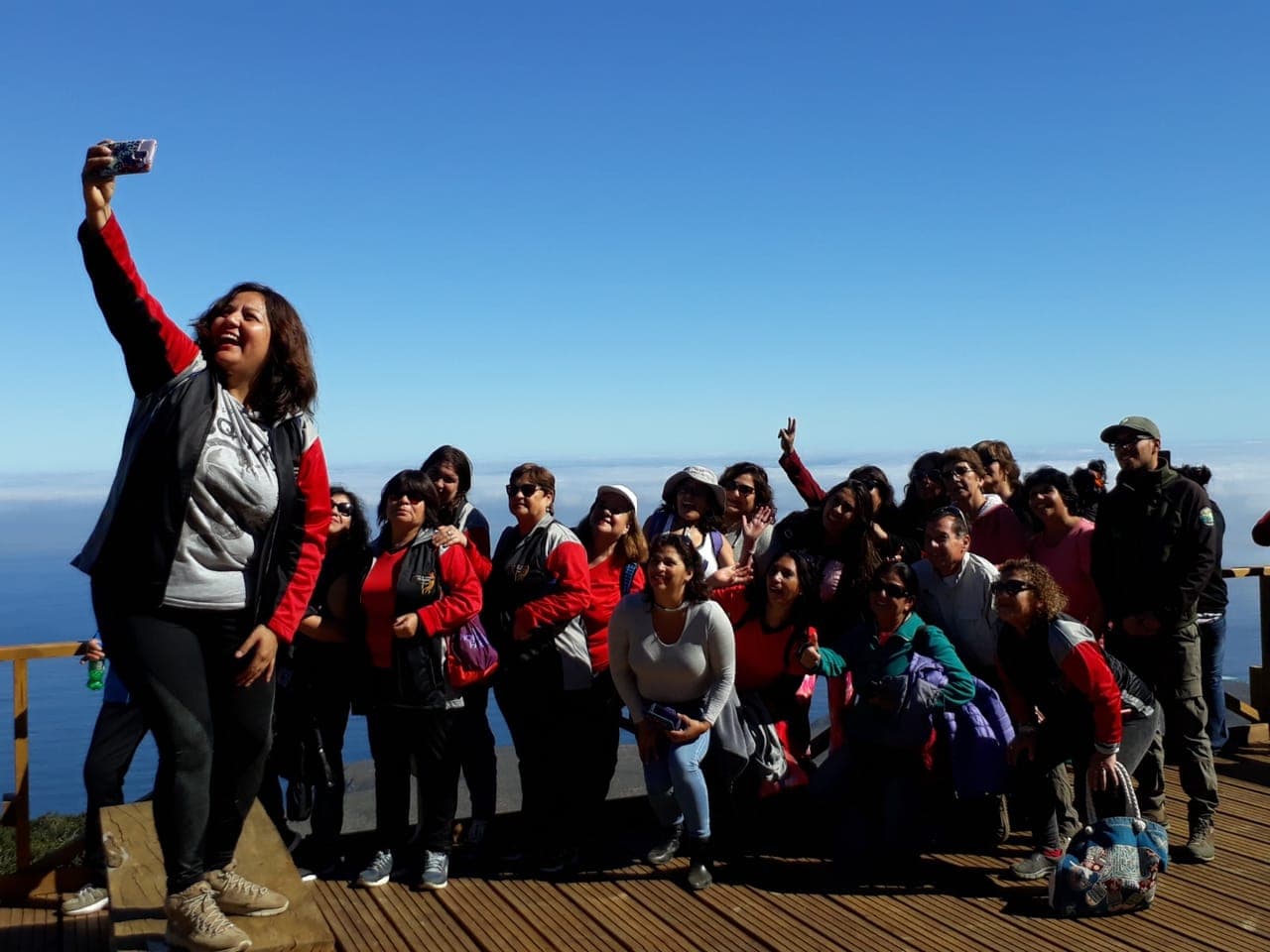 Grupo grande tomándose una fotografía en un mirador costero
