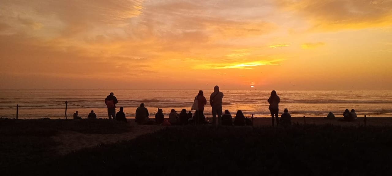 Grupo observando el atardecer en la costa de la Región de Coquimbo